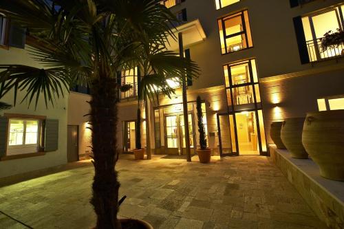 a building with a palm tree in front of it at Hotel Hirschen in Freiburg-Lehen in Freiburg im Breisgau