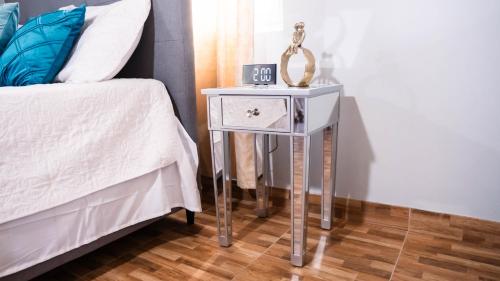a nightstand with a clock on it next to a bed at Sham Suite in Boscobel