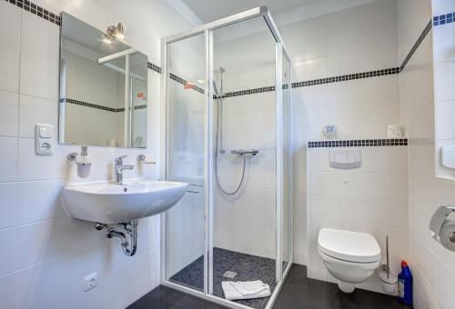 a bathroom with a shower and a sink and a toilet at Haus Störtebeker in Ueckeritz