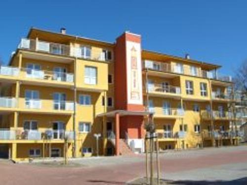 un gran edificio amarillo con un rojo en Ferienwohnung Seestraße, en Zempin