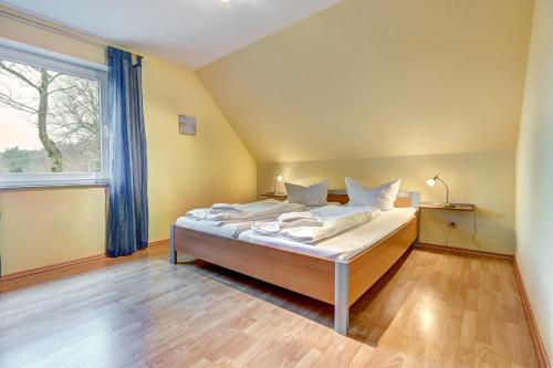 a bedroom with a bed and a large window at Ferienhaus "Seestern" in Karlshagen