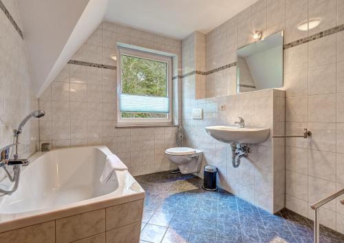 a bathroom with a tub and a sink and a toilet at Ferienhaus "Seestern" in Karlshagen
