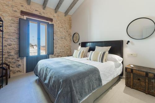 a bedroom with a large bed and a window at Casa Adela - Luxury Rural Accommodation in Castellonet