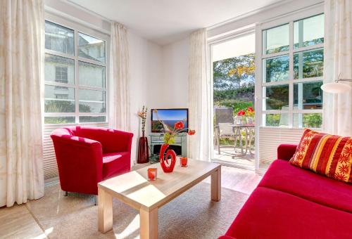 a living room with a red couch and a table at Residenz am Balmer See - BS 45 mit Wellnessbereich in Balm