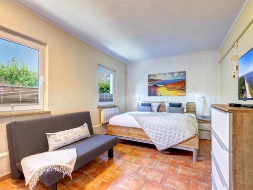 un dormitorio con una cama y un sofá en Bungalow Jonas, en Trassenheide