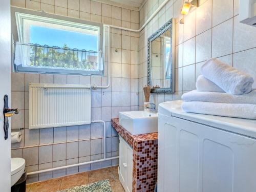 Un baño con lavabo, inodoro y ventana. en Bungalow Jonas, en Trassenheide