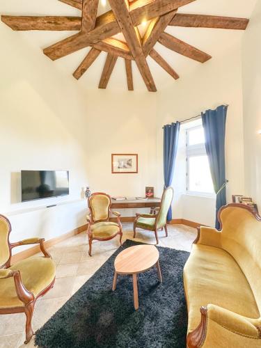 a living room with chairs and a couch and a tv at Château de Tilly in Boissey-le-Châtel