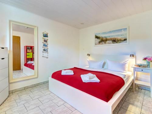 Un dormitorio con una cama grande con una manta roja. en Bungalow Konrad, en Trassenheide