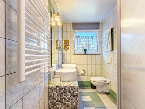 Un baño con inodoro y ventana. en Bungalow Konrad, en Trassenheide