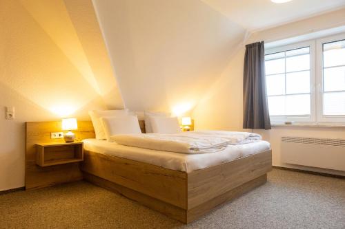 a bedroom with a large bed with a window at Cuxlandhotel Doppelzimmer 123 in Dorum Neufeld