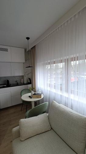a living room with a couch and a table at 120 w 5 gwiazdowym ROYAL TULIP SAND 200 m od plaży DOBRUK APARTAMENTY in Kołobrzeg