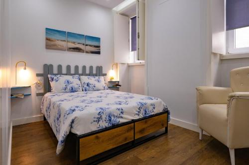 a small bedroom with a bed and a chair at Casa da Ladeira by Trip2Portugal in Figueira da Foz