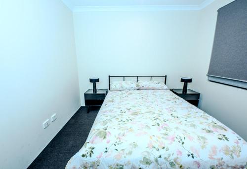 a bedroom with a bed and two night stands at Spectacular 3 Bedroom, 2 Bathroom Home. in West Swan