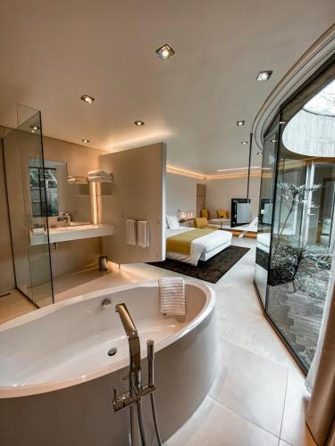 une salle de bain avec baignoire et une chambre avec un lit dans l'établissement MAISON KERVARREC - Rennes - Saint-Grégoire, à Saint-Grégoire