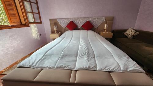 a bedroom with a large bed and a couch at Appartement Riad 5min à pied de l'aéroport in Marrakech