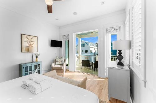 a white bedroom with a bed and a view of the ocean at Sand On Tap in Inlet Beach