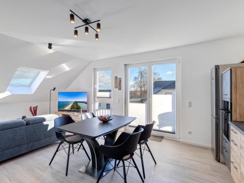 a living room with a table and chairs and a couch at Bernsteinquartier BQ 0447 in Loddin