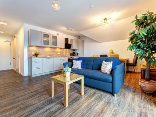 a living room with a blue couch and a table at Bernsteinquartier BQ 0446 in Kolpinsee