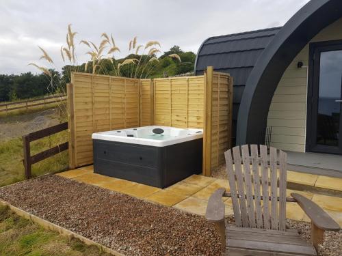 a hot tub and a chair on a patio at Bruadarach 'Visionary, Dreamer' in Dunbeath