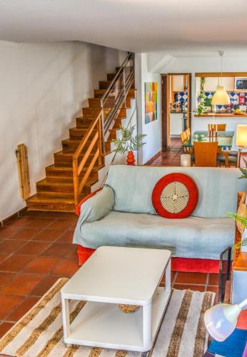a living room with a blue couch and stairs at Casa das Escadinhas in Ericeira