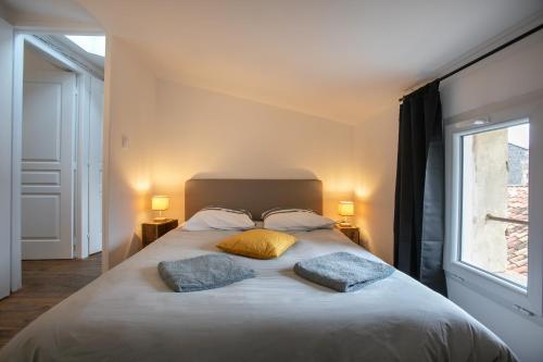 une chambre avec un grand lit avec deux oreillers dans l'établissement Séjour de Charme T3 Centre Historique Bergerac, à Bergerac