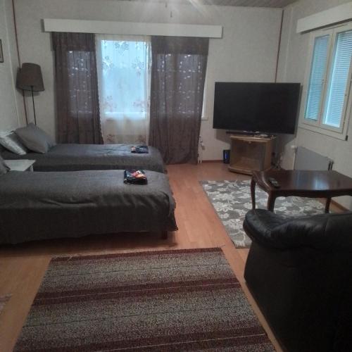 a living room with a couch and a flat screen tv at Perniön majoitus Huoneisto a4 in Perniö