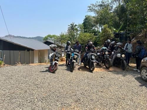 a group of people on motorcycles parked on a gravel road at Serenehills Retreat in Idukki