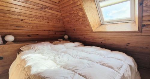 a bed in a wooden room with a window at Appartement à la Trinité sur Mer in La Trinité-sur-Mer