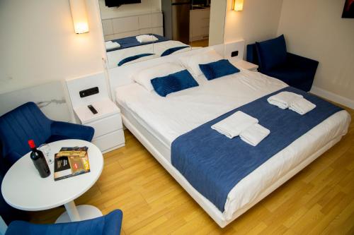 a bedroom with two beds and a table and a chair at Orbi city - Premium Class Rooms N1 in Batumi