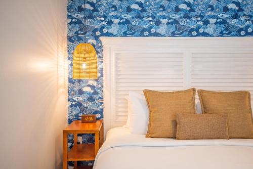 een slaapkamer met een bed en een blauwe muur bij Underwater Cabana at Custom House Inn in Key West