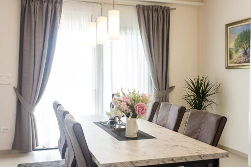 a dining room with a table and chairs with flowers on it at View Villas Collection in Vinišće