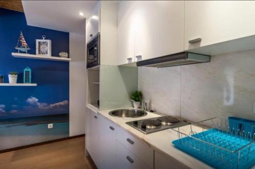 a kitchen with a sink and a counter top at Apartamento dos Peixes in Sesimbra