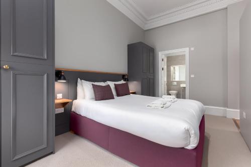 a bedroom with a large bed and a table at Destiny Scotland - Distillers House in Edinburgh