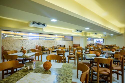 a restaurant with tables and chairs in a room at Nordeste Palace Hotel - Fortaleza in Fortaleza