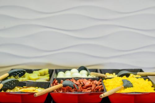 a tray of different types of food on a table at Nordeste Palace Hotel - Fortaleza in Fortaleza