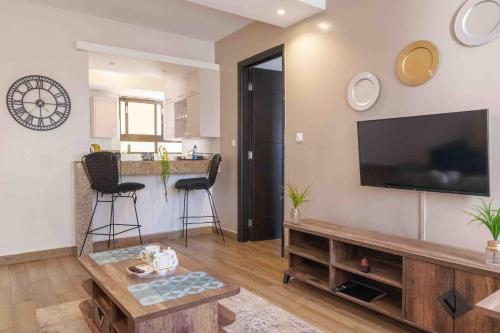 un salon avec une télévision à écran plat sur un mur dans l'établissement Wellivia Suites Serviced Apartments, à Nairobi