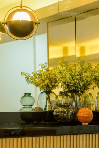 a black counter with vases and flowers on it at Nordeste Palace Hotel - Fortaleza in Fortaleza