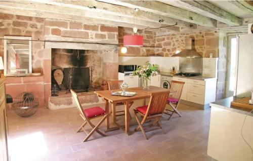 une cuisine avec une table en bois et une cheminée dans l'établissement Maison accueillante avec vue sur le jardin à Villac, à Villac