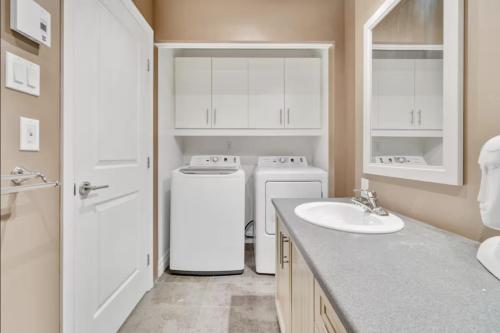 a bathroom with two washers and a sink and a counter at INITIAL - TEMPLE - Chutes-Montmorency in Boischâtel