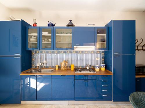 Una cocina azul con gabinetes azules y un fregadero. en Holiday Home Laura - DOL281 by Interhome, en Bellissimi