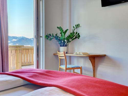 a bedroom with a desk and a table with a plant at Apartment Residence Egger - n-301 by Interhome in Villandro