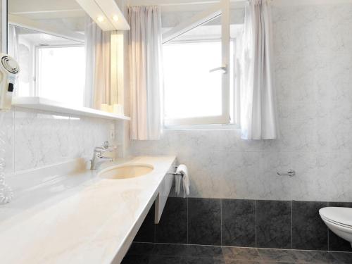 a white bathroom with a sink and a toilet at Apartment Residence Egger - n-301 by Interhome in Villandro