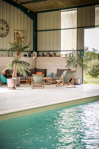 une maison dotée d'une piscine avec des chaises et une table dans l'établissement La roulotte MAGIC ! des Grillots, à Beaulon