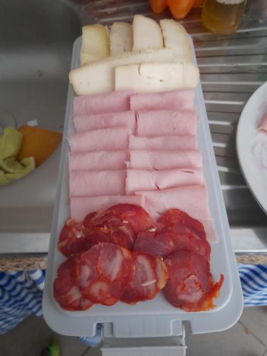 un récipient en plastique rempli de différents types de viandes et de fromages dans l'établissement O Cantinho da Auzenda, à Torre de Moncorvo