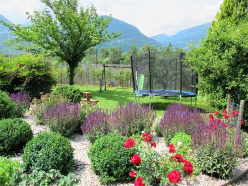 a garden with flowers and a playground at Apartment Schöneck by Interhome in Postal