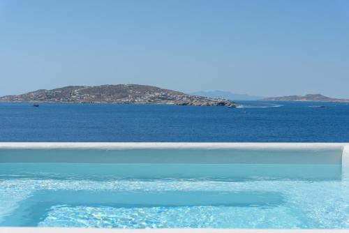 a large body of water with an island in the background at Rocabella Mykonos Hotel in Agios Stefanos
