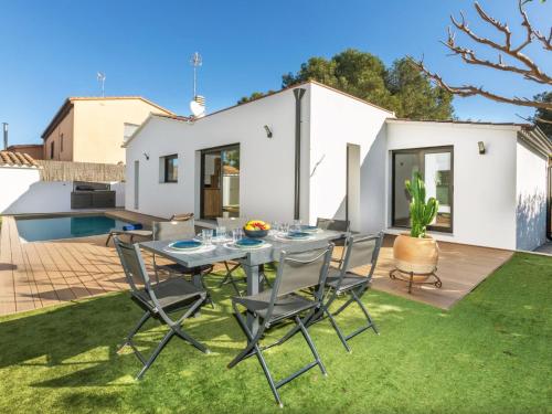 een patio met een tafel en stoelen op het gras bij Holiday Home La Manzaneta by Interhome in Calonge
