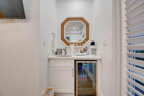 een badkamer met een wastafel en een spiegel bij Sunshine State at Custom House Inn in Key West
