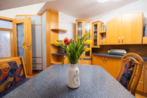 a vase with flowers on a table in a kitchen at Petzen Panorama in Feistritz ob Bleiburg