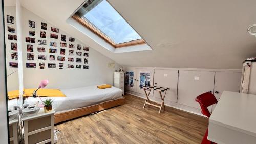 une chambre avec un lit et une lucarne dans l'établissement Large, quiet, familial top floor duplex, à Paris